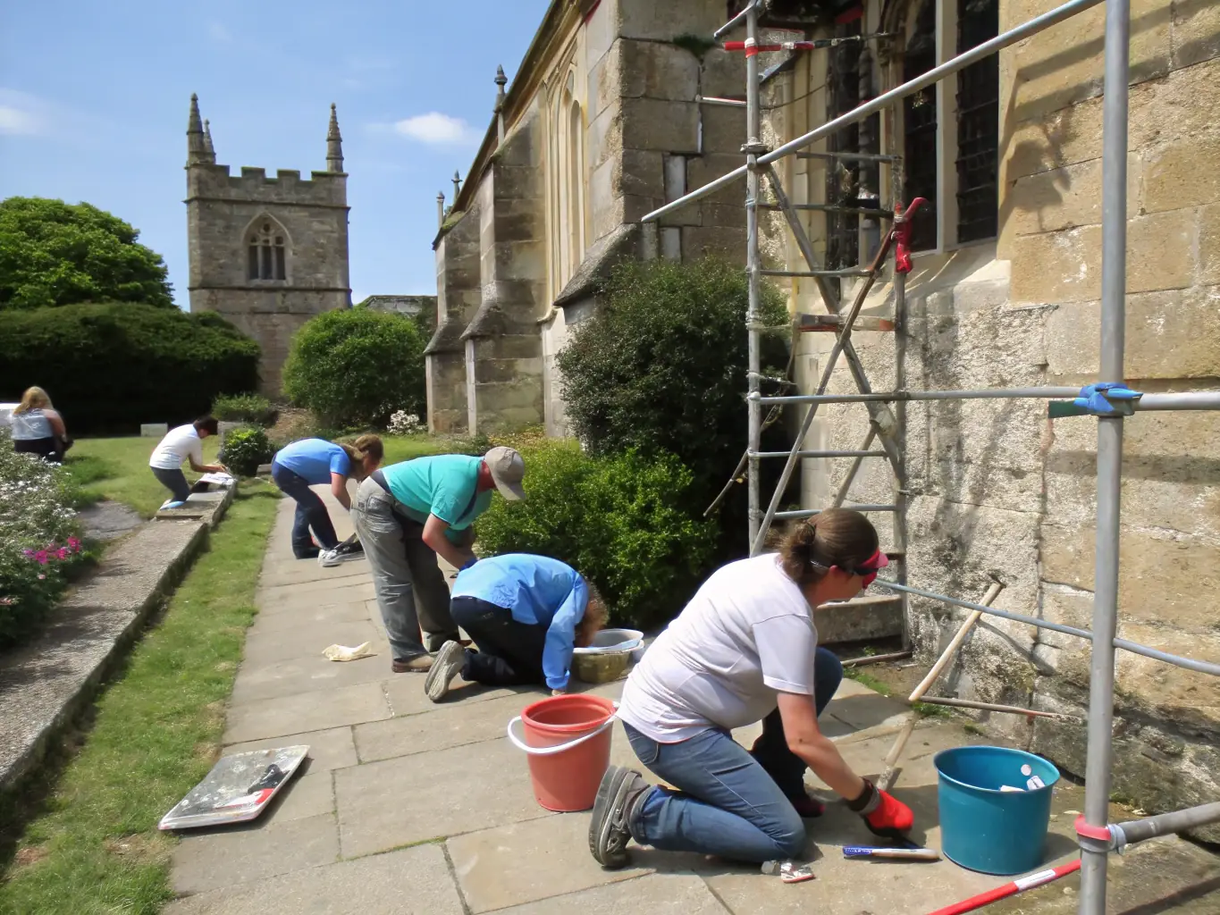 A photograph capturing volunteers carefully cleaning and restoring a section of the chapel's interior, showcasing the meticulous work involved in preserving historical details.